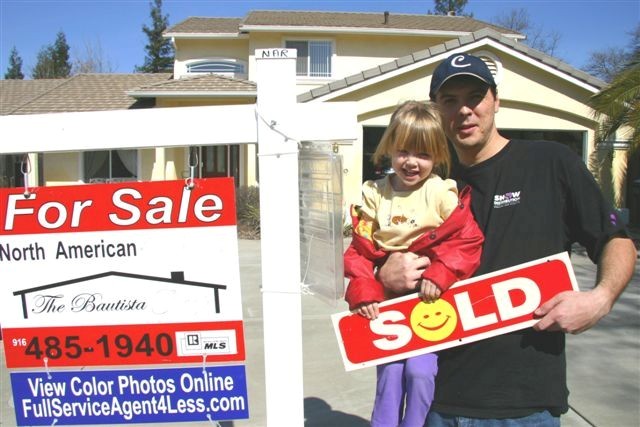 Photo of 1 of our Sellers with a Sold sign in front of their home.