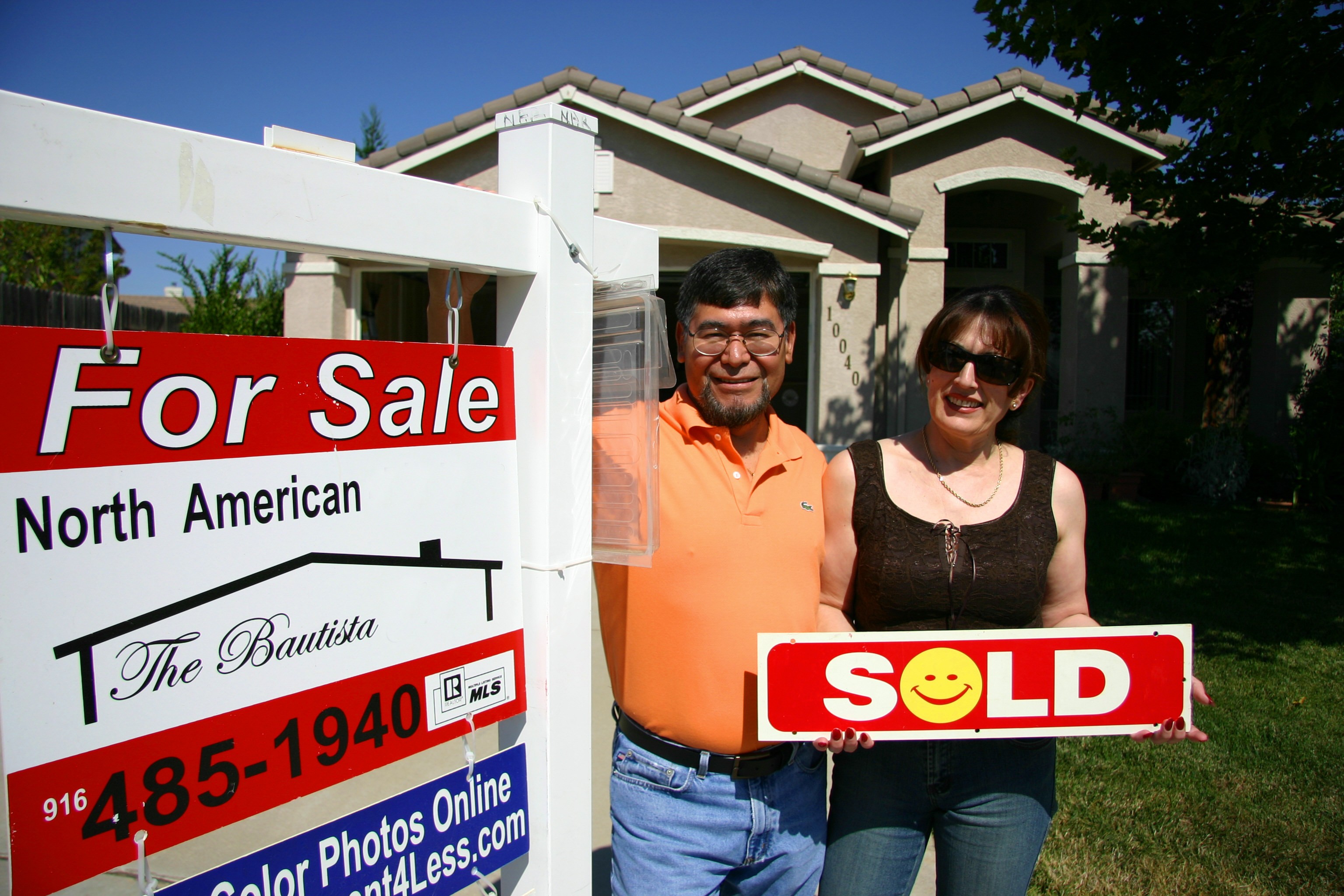 Photo of 1 of our Sellers with a Sold sign in front of their home.